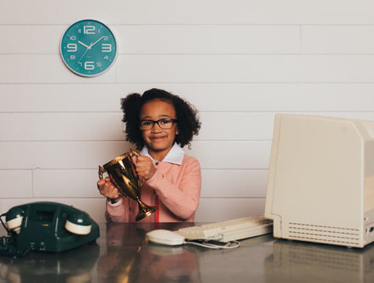 young girl in business clothing holding a trophy