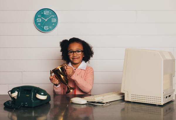 young girl in business clothing holding a trophy