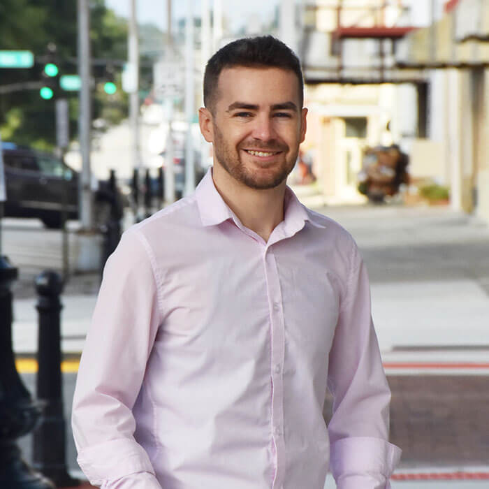 Nathan Chase smiling and standing on Downtown Macon sidewalk