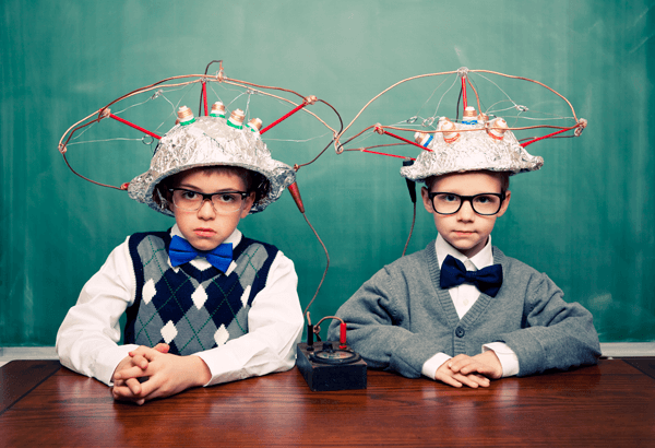2 young boys in tinfoil hats connected with electrical wiring