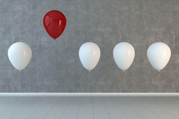 red balloon arranged in a line of white balloons and is floating higher