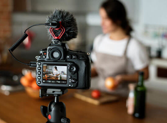 a DSLR camera is filming a woman preparing a recipe