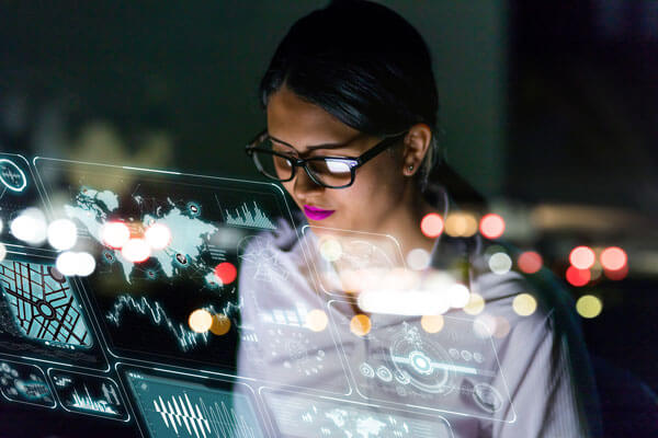 female engineer analyzes data displayed by a hologram