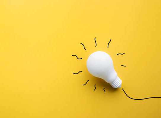 white plaster lightbulb sitting on a yellow background