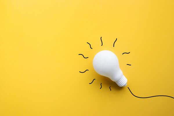 white plaster lightbulb sitting on a yellow background