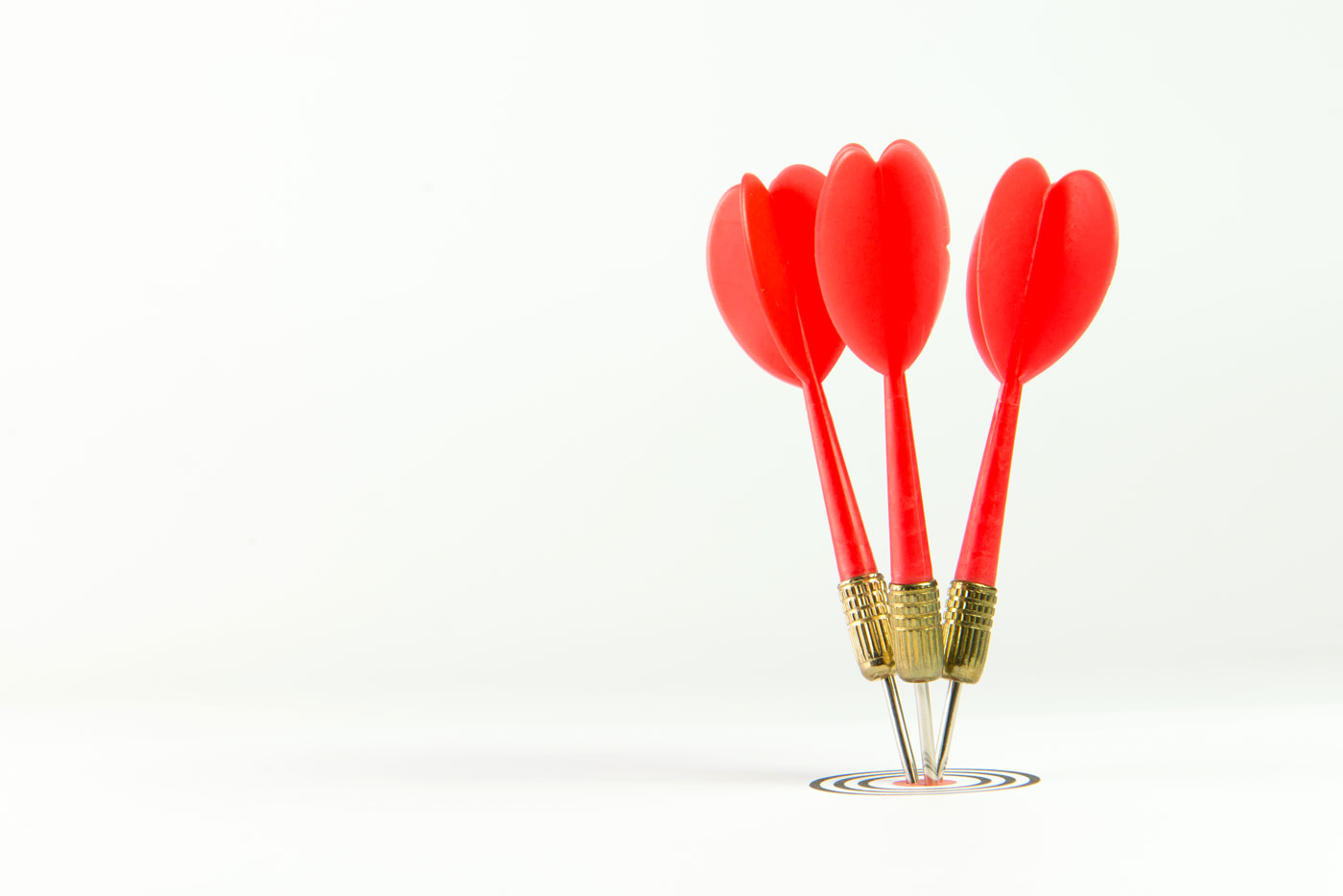 Three red darts pinned right on the center of dartboard