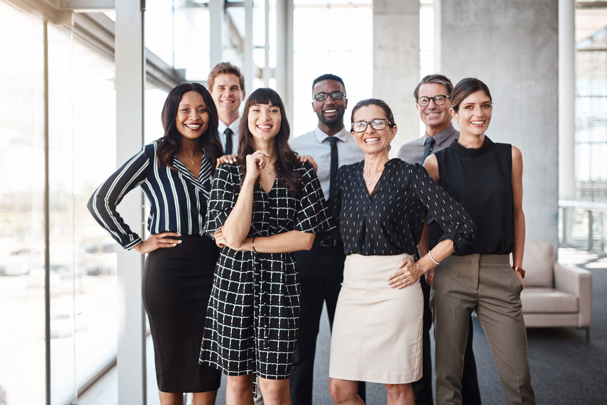 group of young professionals smiling and working in an office environment