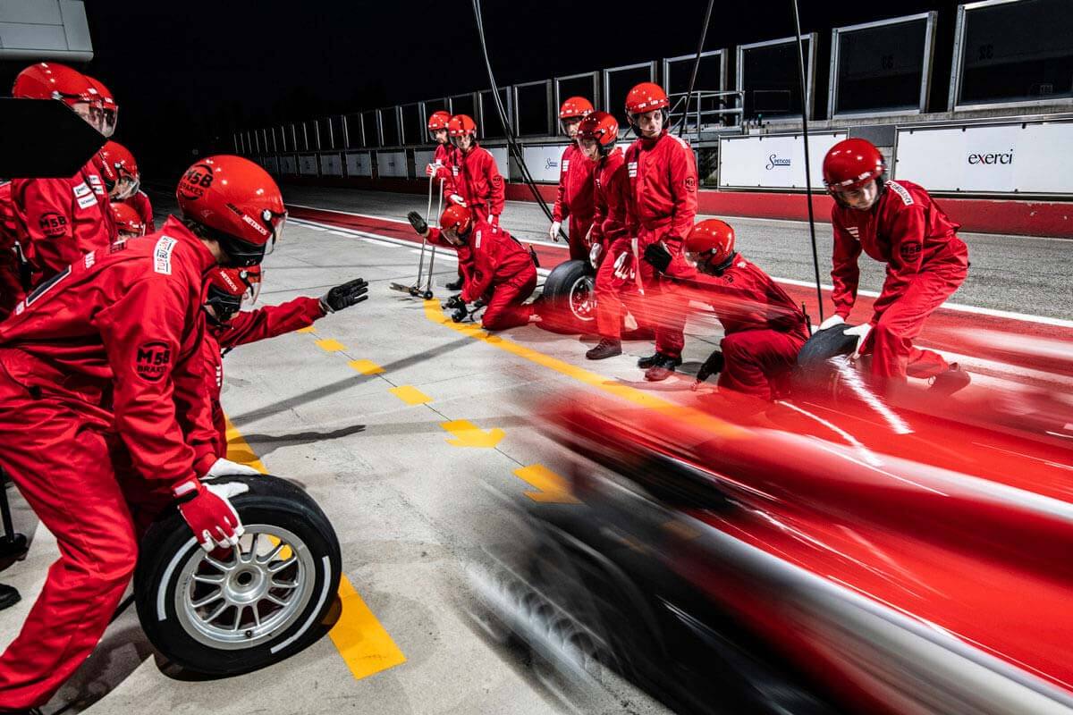 racing pit crew in the midst of changing a tire