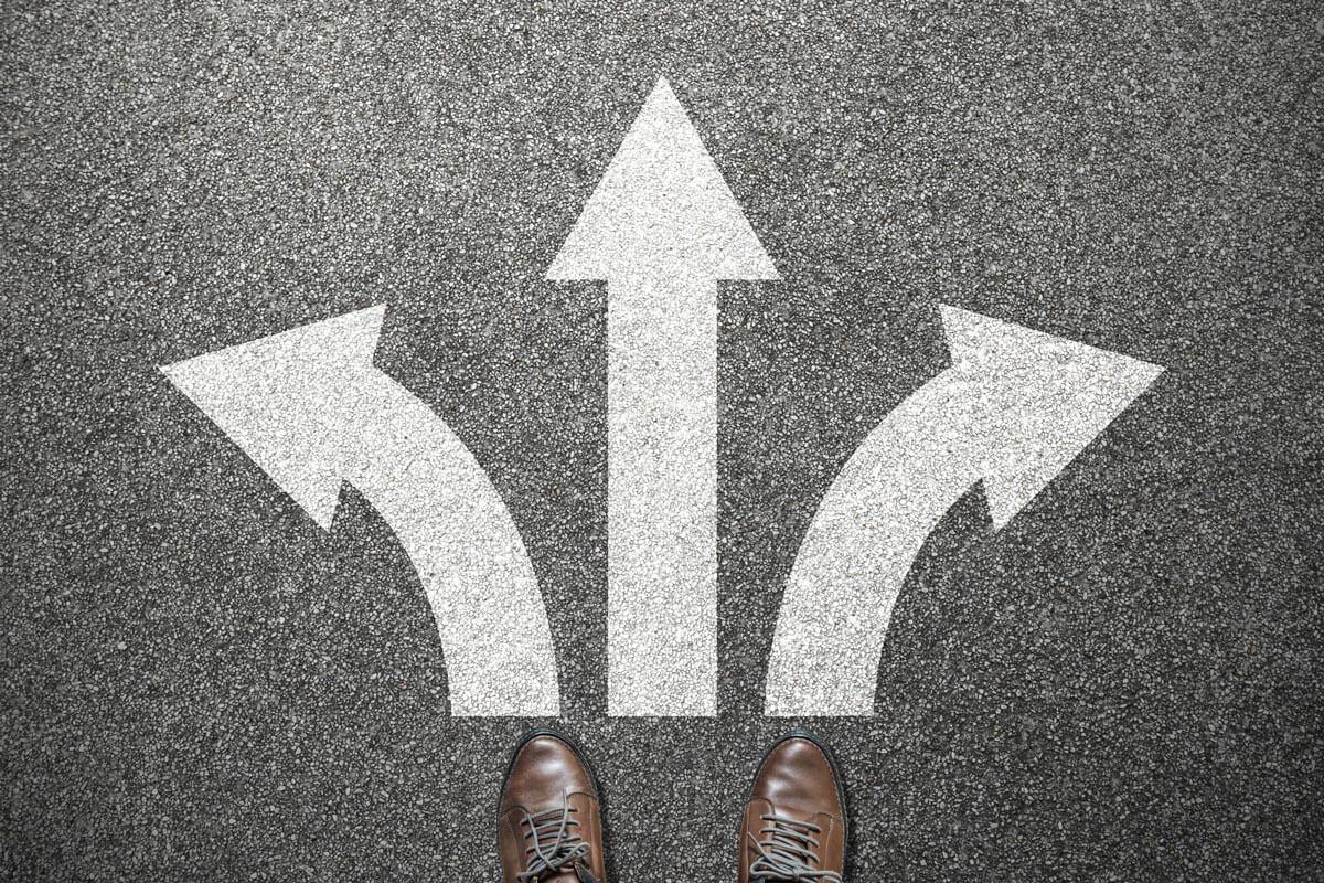 a pair of shoes in front of some arrows on a street that point in different directions