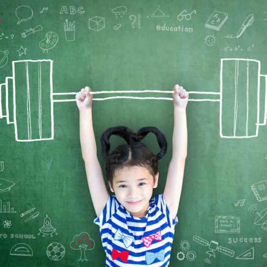 a young girl holds up a barbell