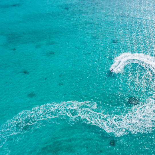 a jetski in the middle of a clear and shallow ocean