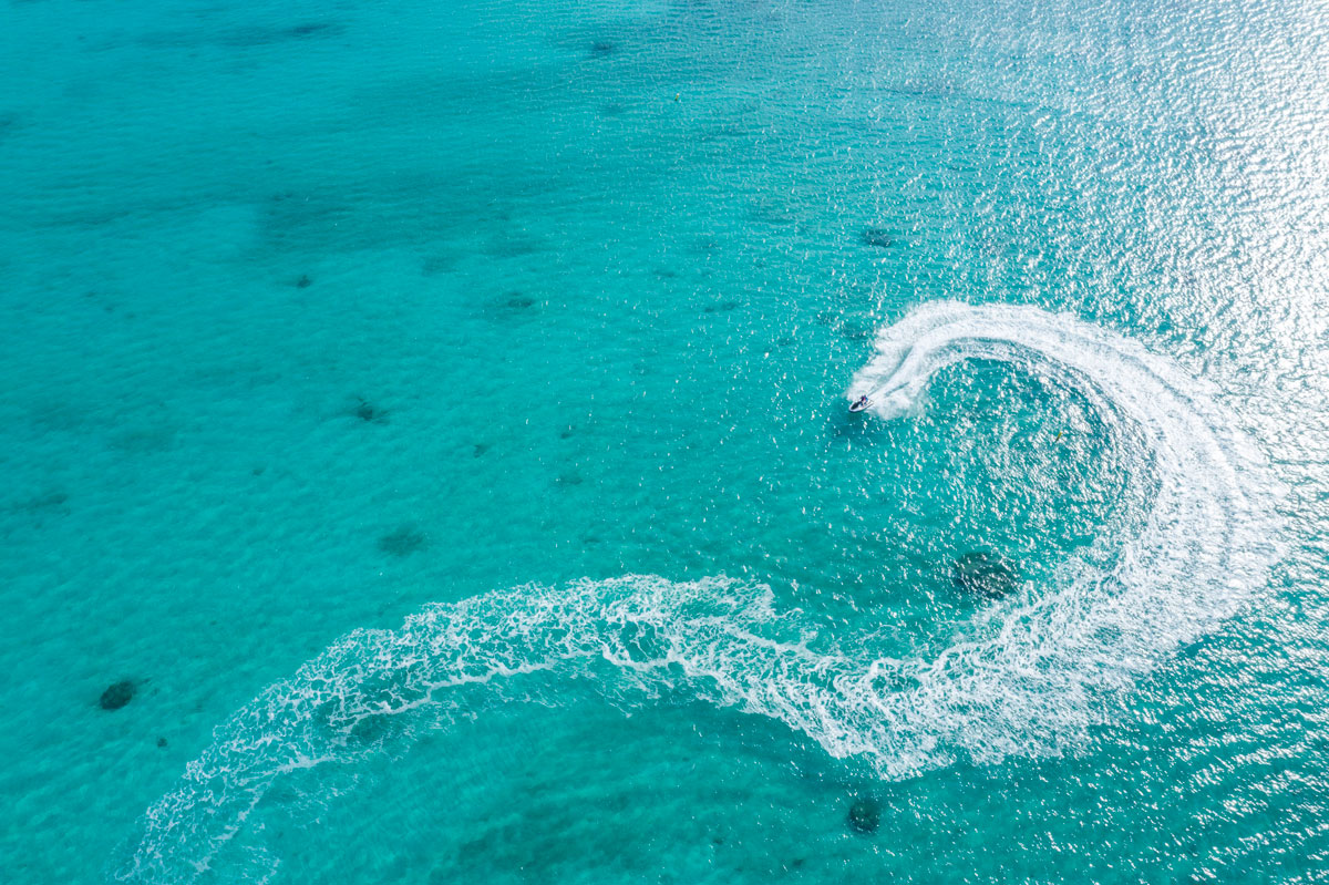 a jetski in the middle of a clear and shallow ocean