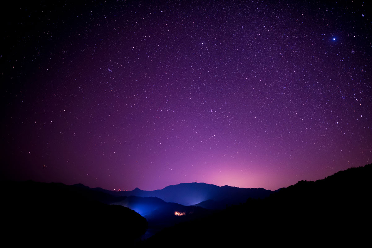 a starry night with a purple sky