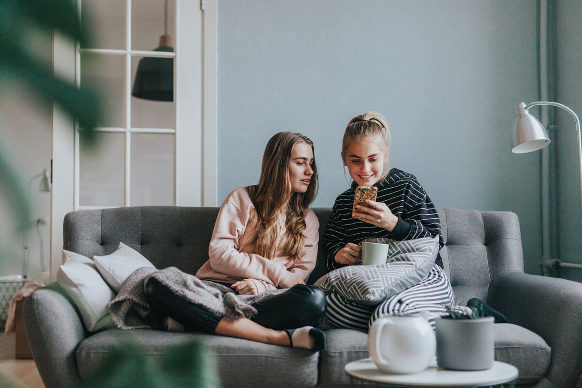 2 girls browse the internet with their phones