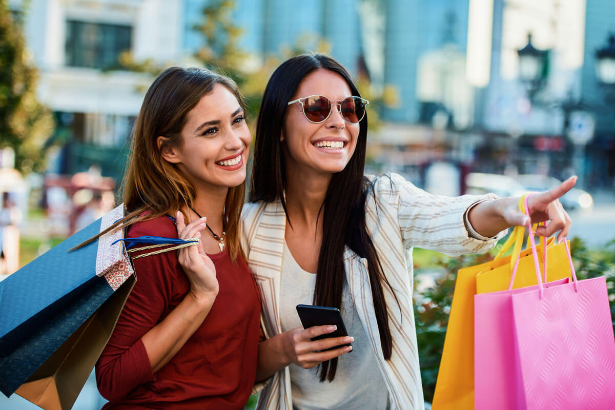 two happy smiling female shoppers