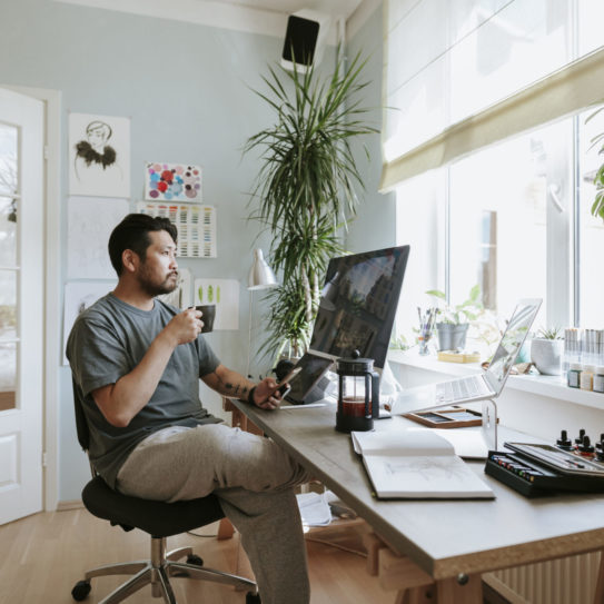 Digital artist contemplates during coffee break in his home office