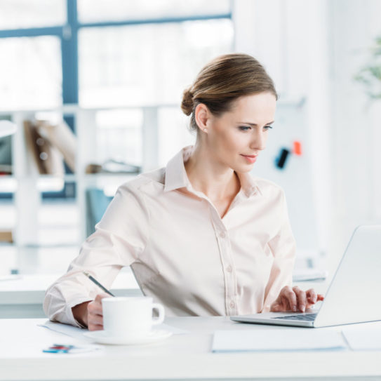 young businesswoman in formalwear working on laptop at office