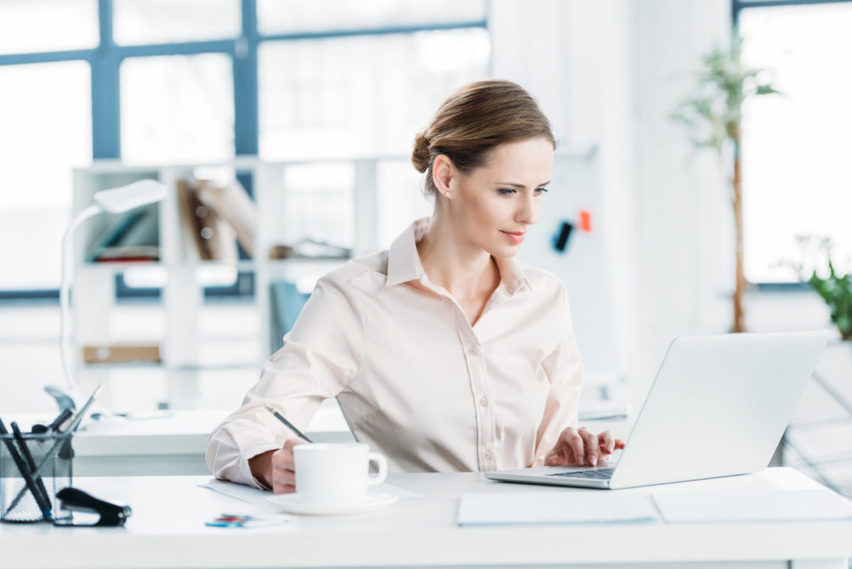 young businesswoman in formalwear working on laptop at office