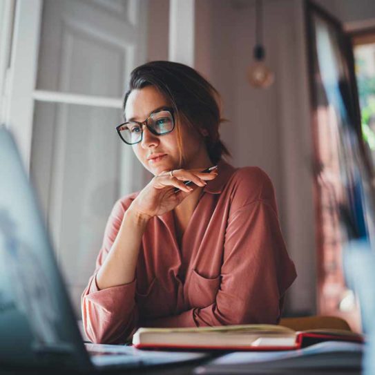 business woman sitting at table opposite laptop in work