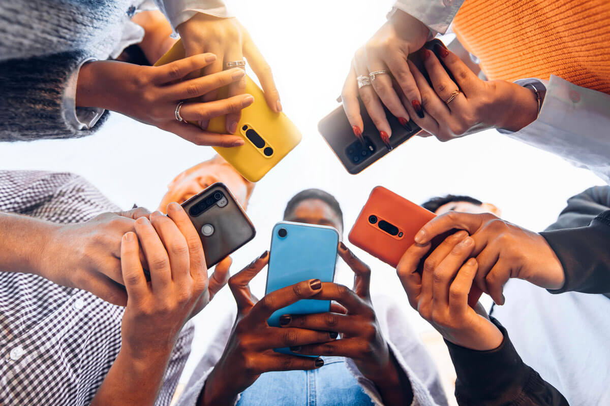 a group of people standing a in a circle and using their phones