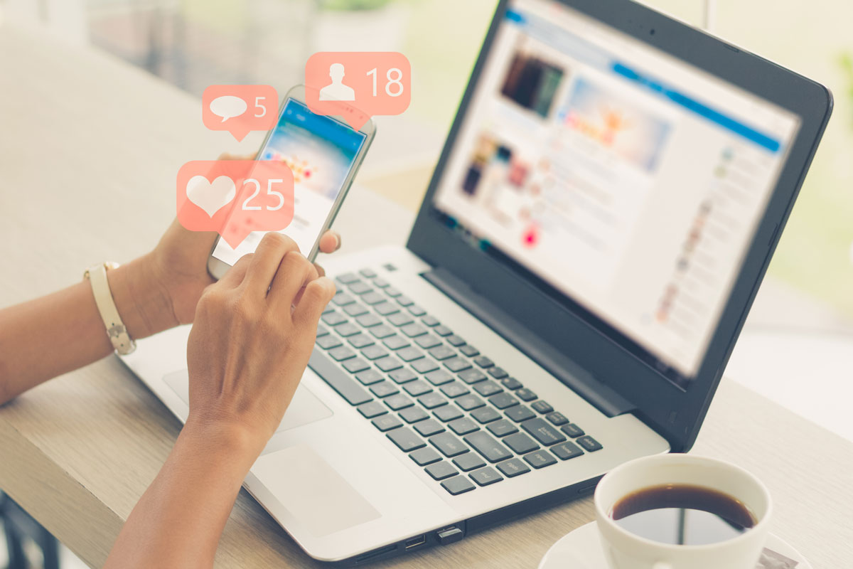 a woman is accessing a social media account on her phone and laptop