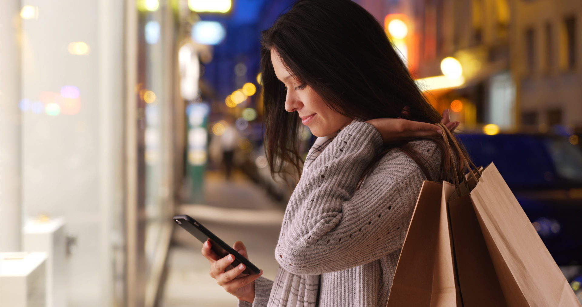 female carrying shopping bags and texting