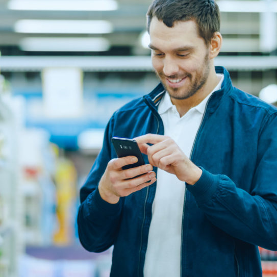 Man Uses Smartphone, Smiles