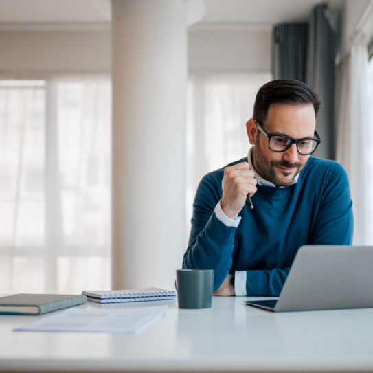 Serious businessman working on laptop