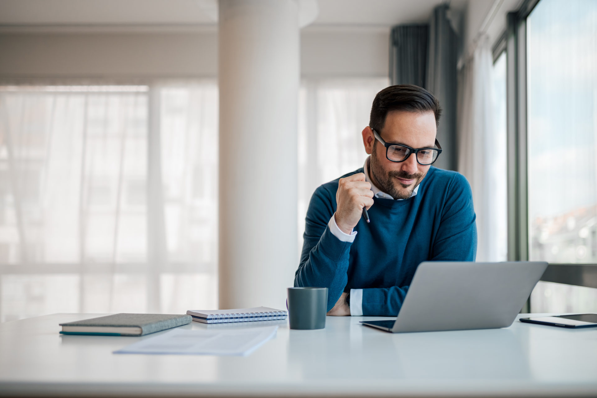 Serious businessman working on laptop