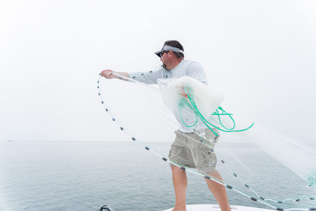 man casting fishing net