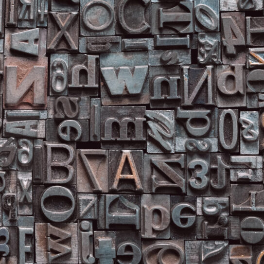 Letterpress background, close up of many old, random metal letters with copy spac