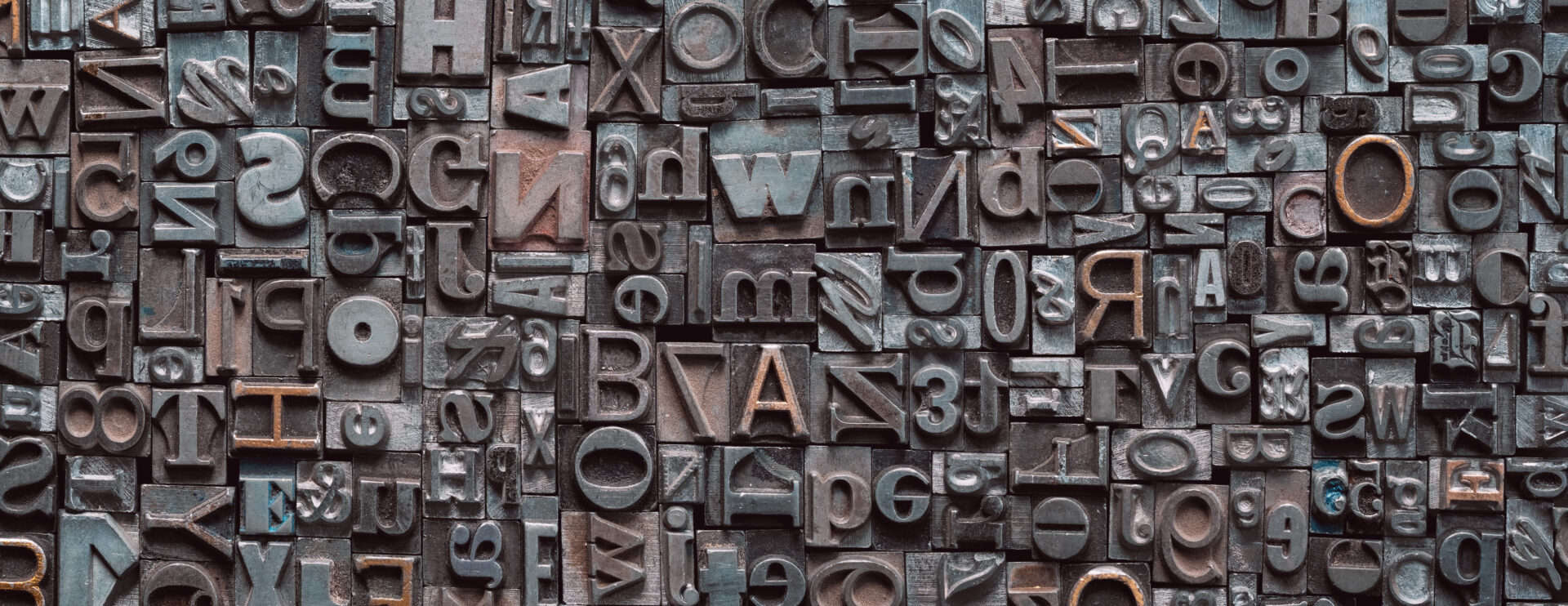 Letterpress background, close up of many old, random metal letters with copy spac