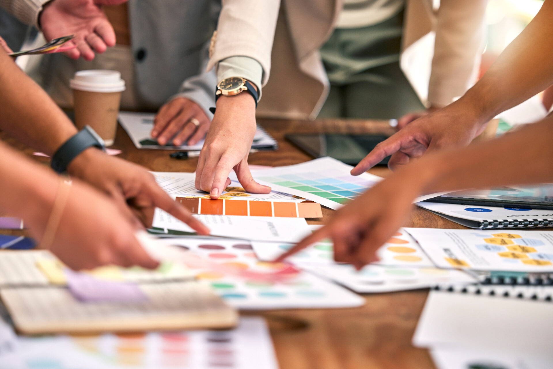 Creative meeting, color and hands of business people on desk for branding logo, strategy and marketing design.