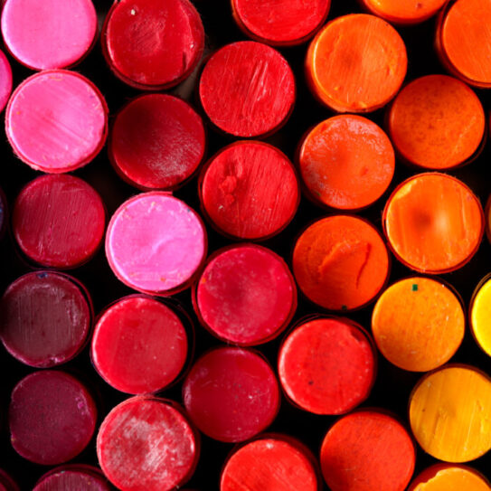 A collection of crayons, viewed from the end, creating a rainbow effect.