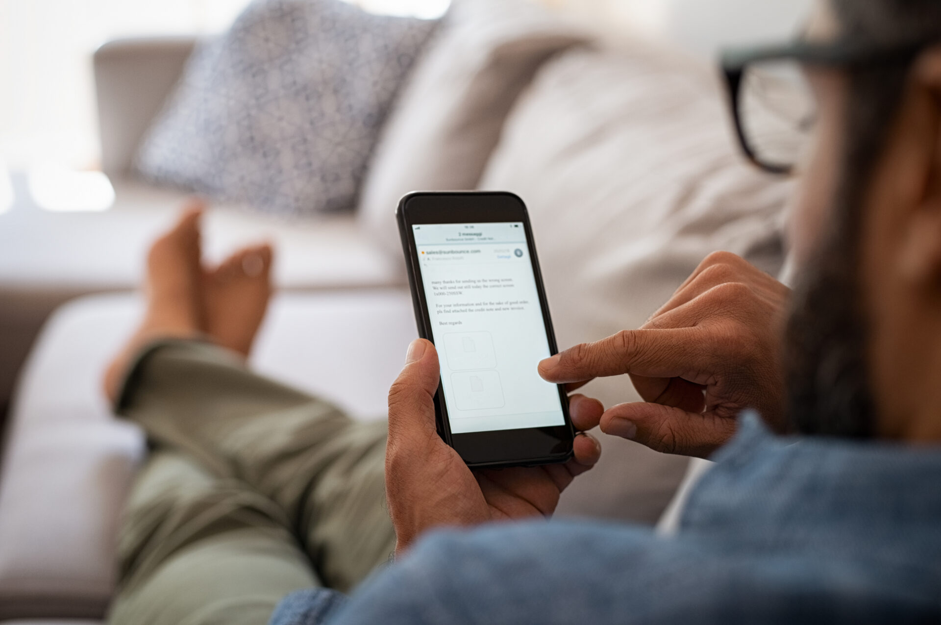 A man checks his email on his mobile phone.