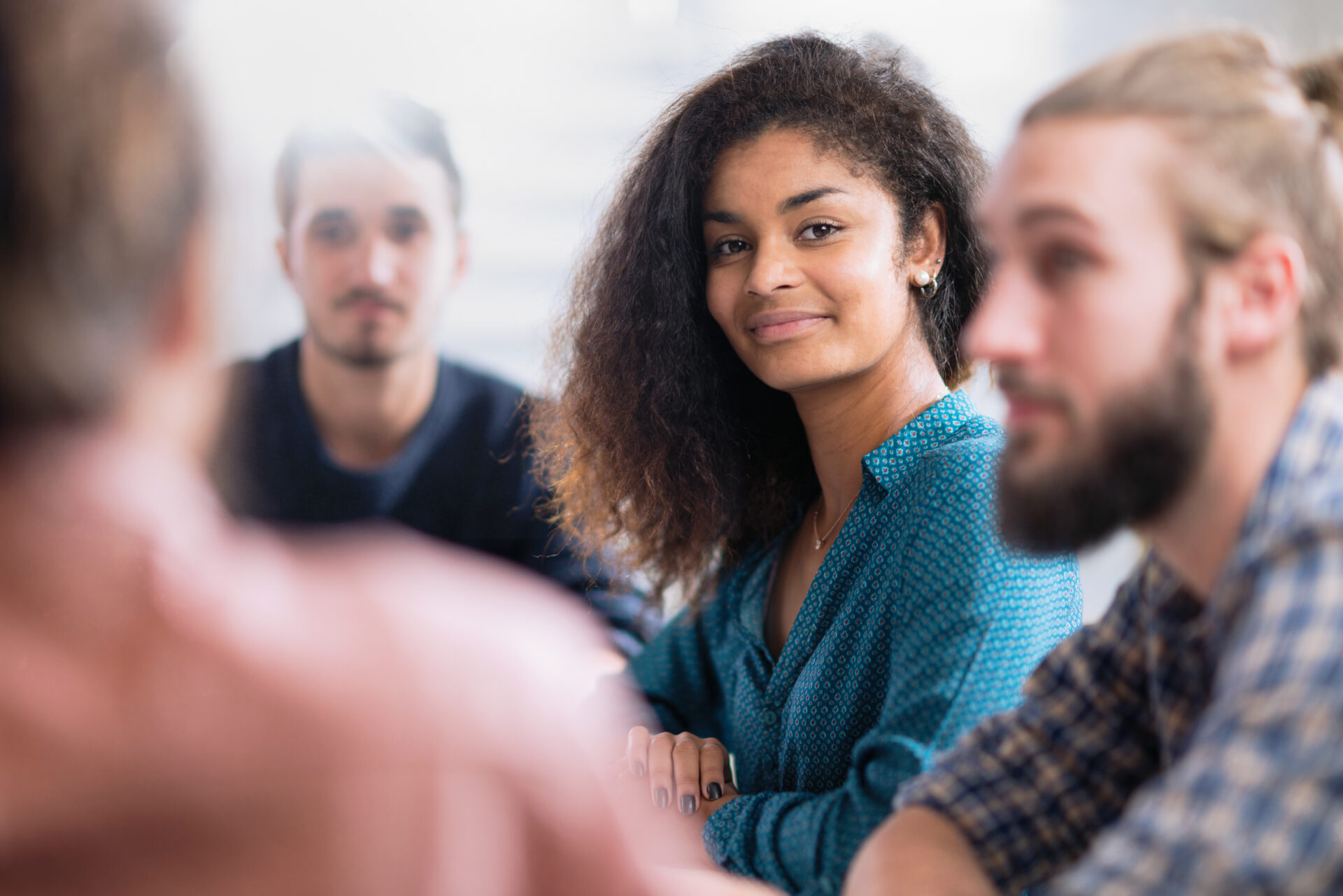 Meeting at the startup office . A working group meets to study a new project. Focus on a beautiful young black woman looking at camera