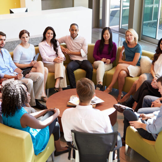 Multi-Cultural Office Staff Sitting Having Meeting Together