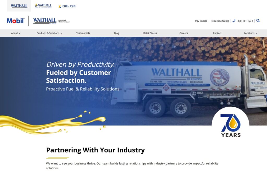 A Walthall Oil Company fuel truck is parked in front of stacked logs. The website highlights Driven by Productivity. Fueled by Customer Satisfaction and features a 70 years logo and oil splash graphic.