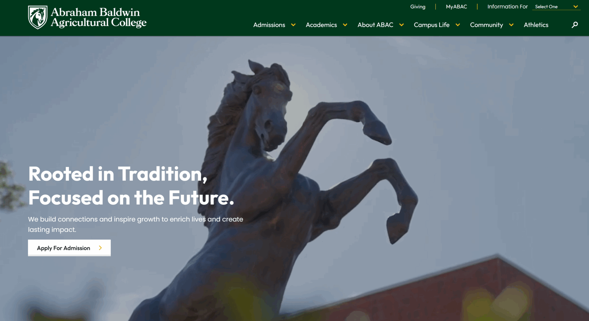 A bronze horse statue rears on its hind legs before a blurred building, with text Rooted in Tradition, Focused on the Future and an Apply for Admission button overlay.