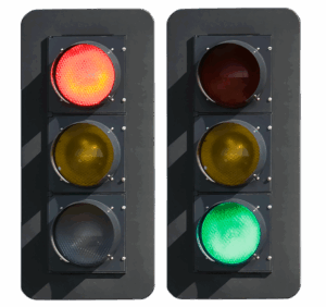 Two vertical traffic lights are shown. The left light is red, the right is green. Each has red, yellow, and green circular lenses.